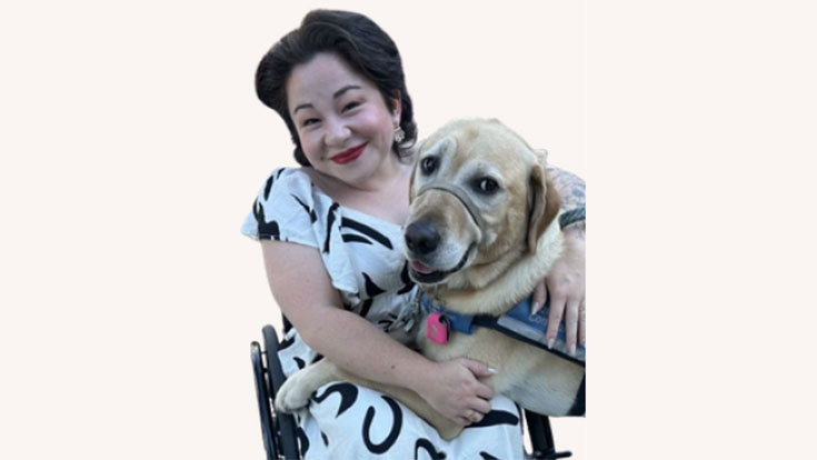 Rosemary McDonnell-Horita seated and hugging a service dog